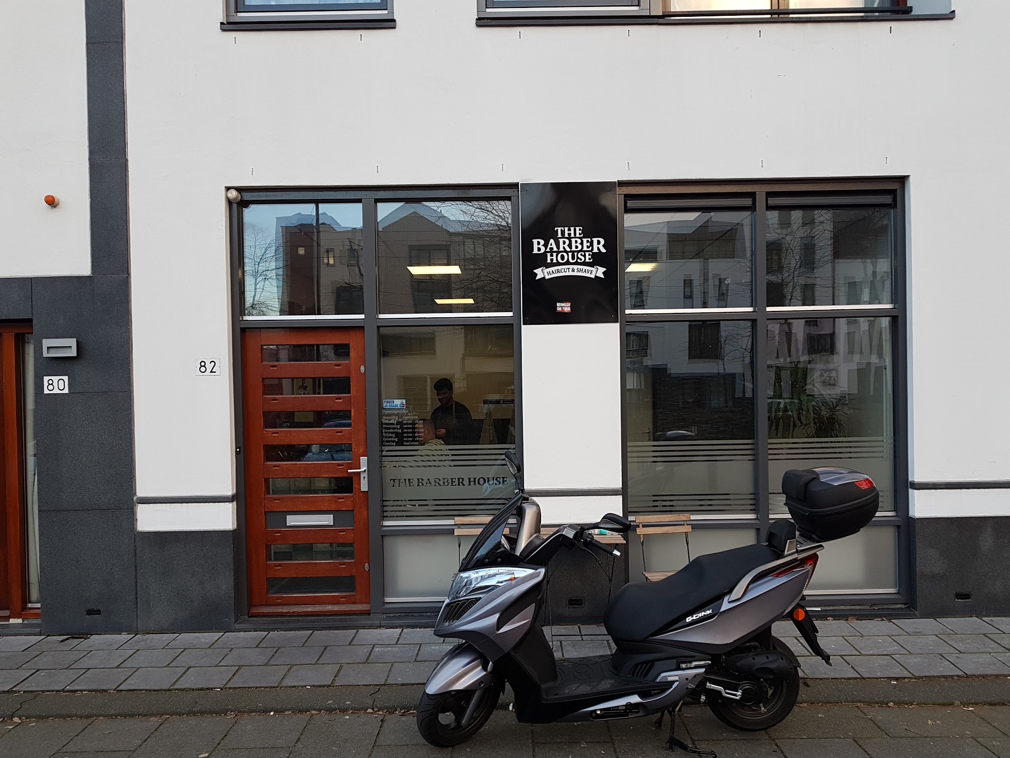 De voorkant van The Barber House aan de Avenue Carnisse 82, met het logo in het raam